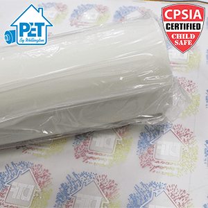 Picture of a roll of PET film on top of a sheet of DTF transfers