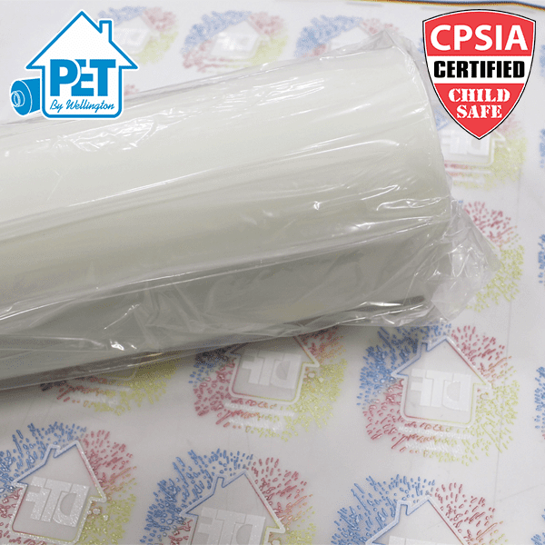 Picture of a roll of PET film on top of a sheet of DTF transfers